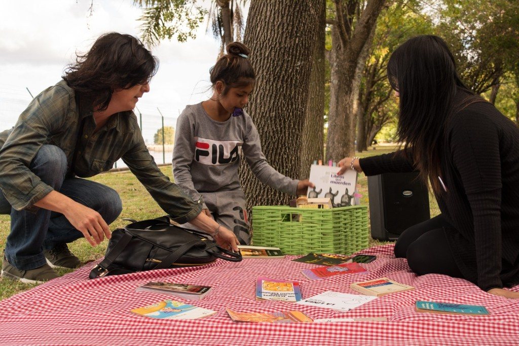 Selección de libros sobre una manta en una actividad comunitaria